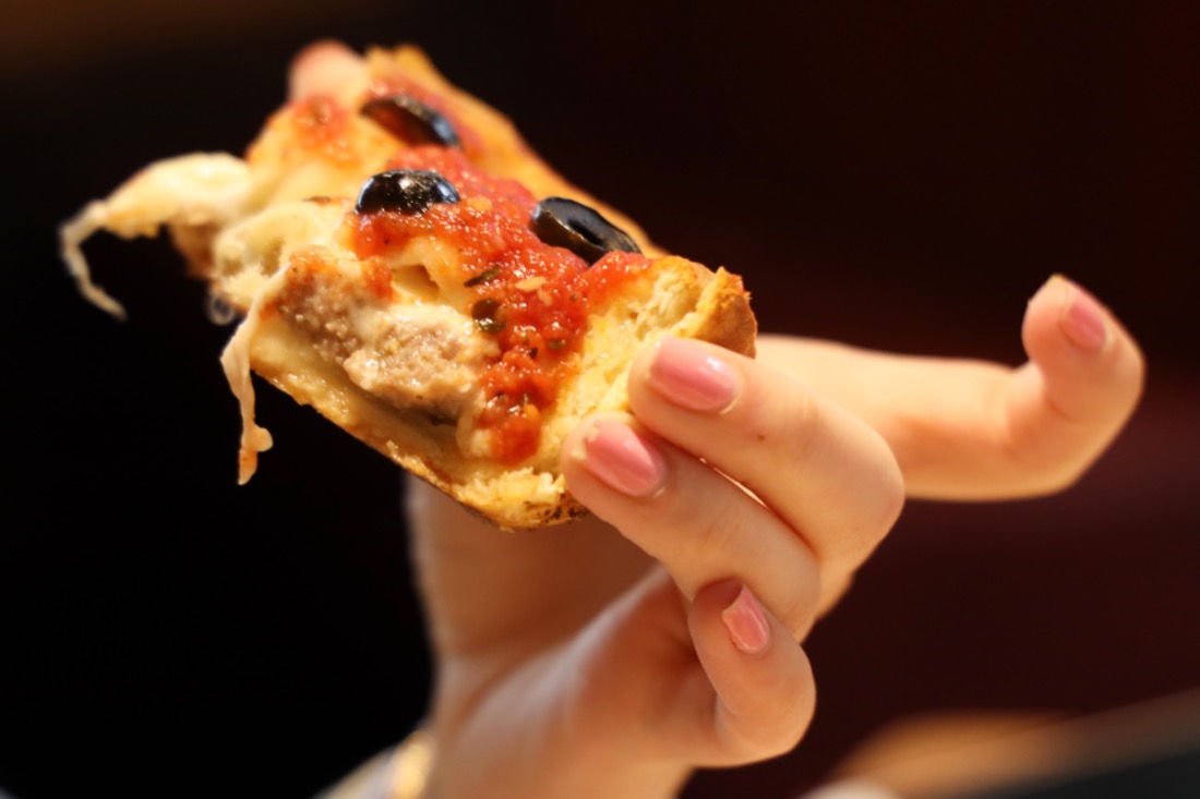 Hand holding Chicago style Deep pan pizza
