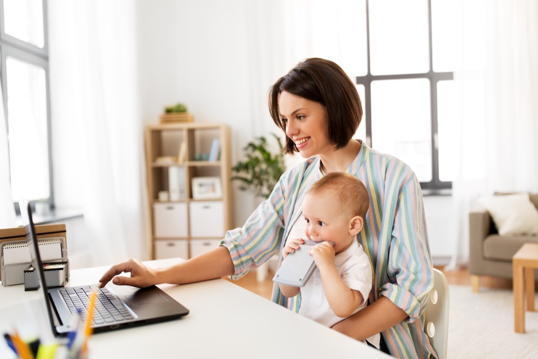 Mum with baby sitting in front of a laptop