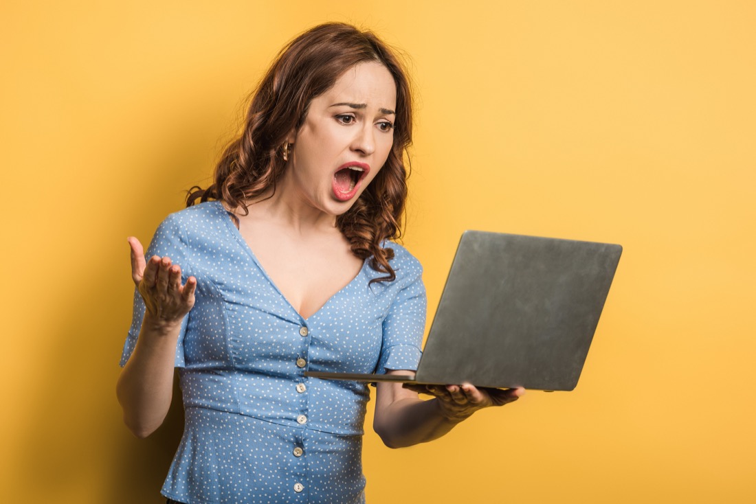 Woman angry looking at a laptop