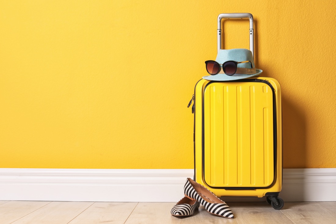 Yellow suitcase with hat and sunglasses