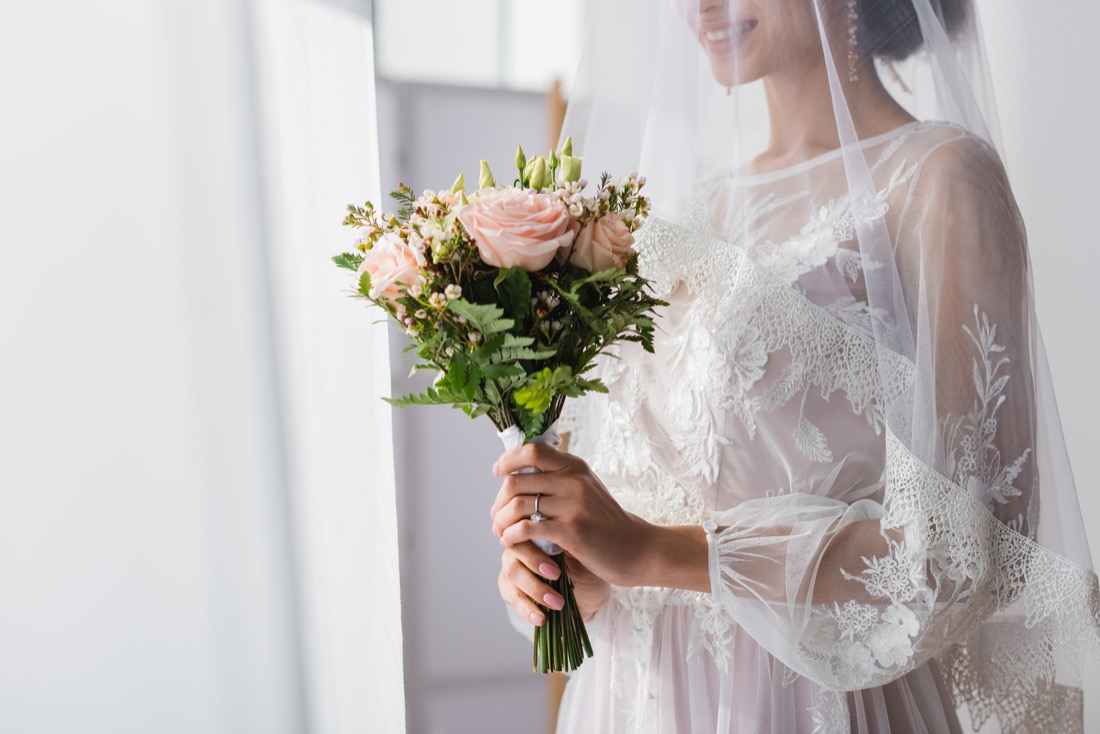 Cropped view of african american bride holding wedding bouquet