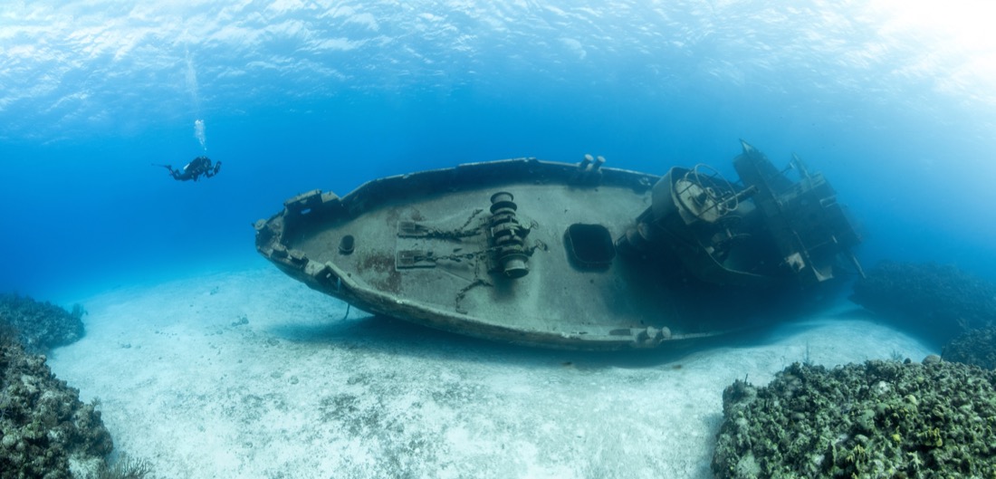 The Scuba divers examining the famous USS Kittiwake submarine wreck in the Grand Cayman Islands. Caribbean.