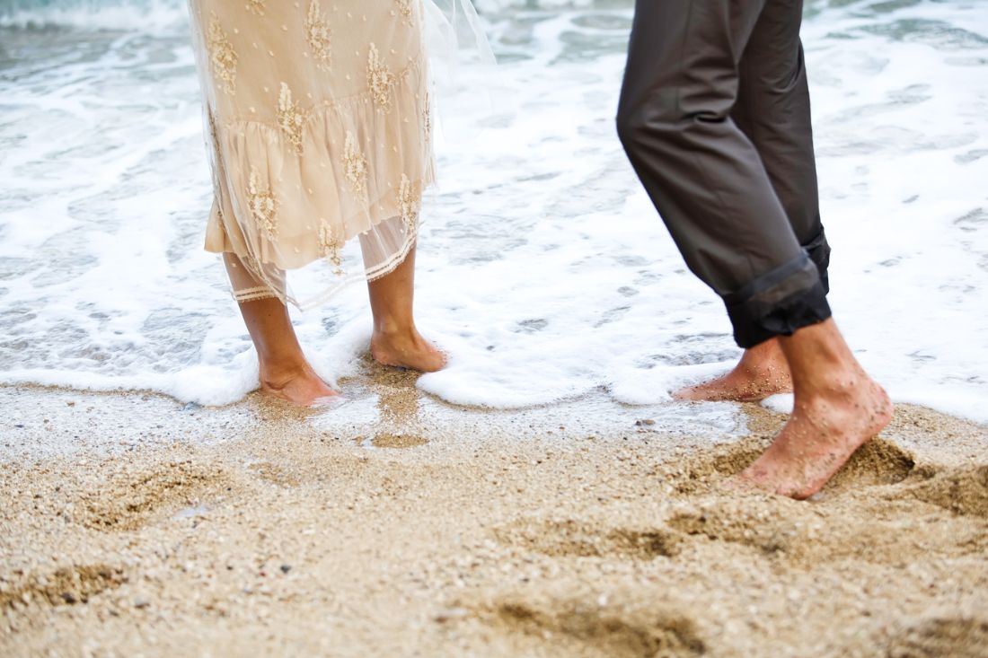 Couple's feet on the sand at a beach