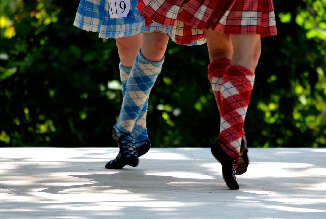 Two Highland dancers in kilts dancing on stage