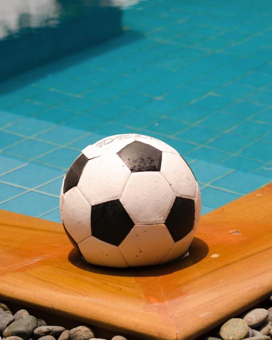 Football or soccer ball by water 