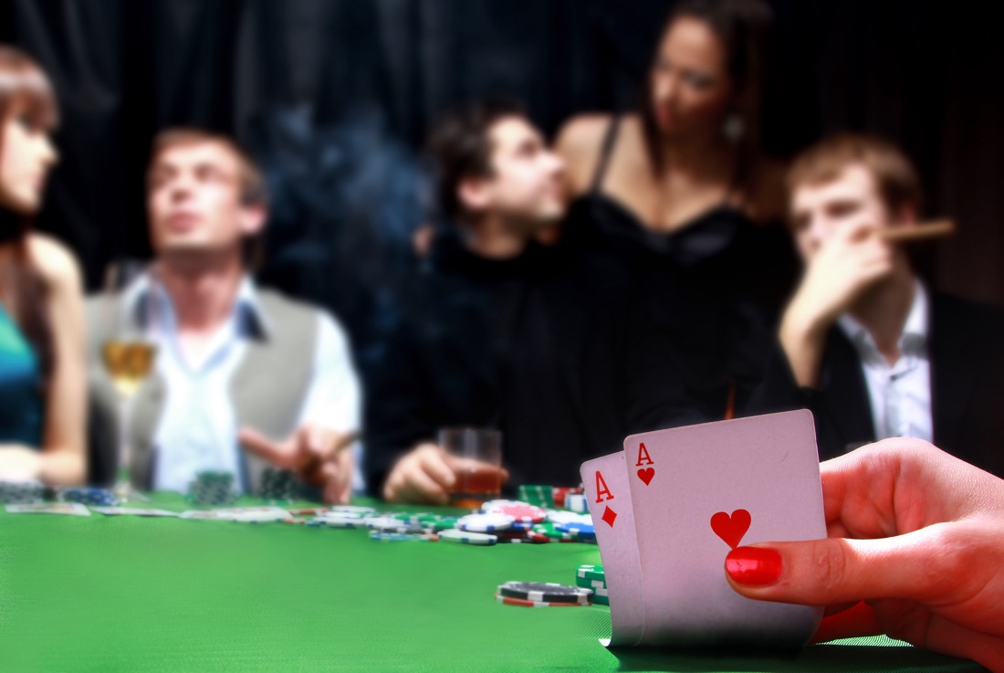 Hand reveals poker card as players chat in background